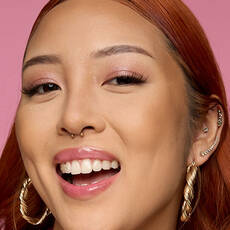 Modelo usando NYX Make 'Em Wonder™ Base de maquillaje en color 16 Natural Beige with glossy lips and pink shimmer eyes.
