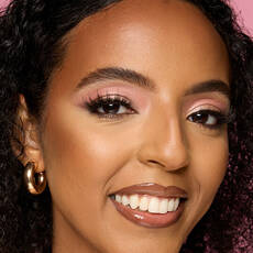Modelo usando NYX Make 'Em Wonder™ Base de maquillaje en color 27 True Caramel with pink eyeshadow and glossy lips.