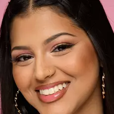 Modelo usando NYX Make 'Em Wonder™ Base de maquillaje en color 20 Classic Tan with bronzed cheeks and glossy nude lips.